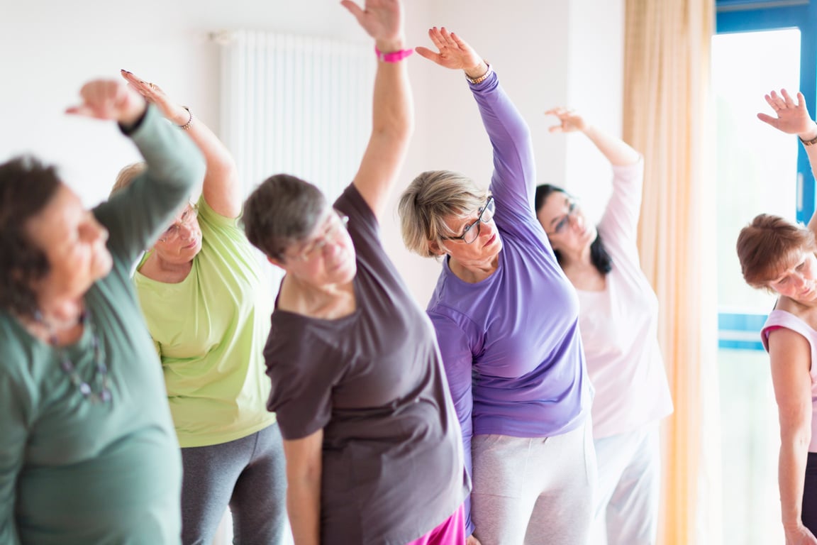 Senior women doing yoga for Alzheimer's care.